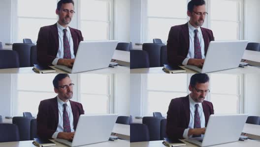 在笔记本电脑上打字前伸懒腰的男人高清在线视频素材下载