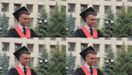 年轻自信的男生戴着毕业帽在学校附近摆姿势拍照，学生高清在线视频素材下载