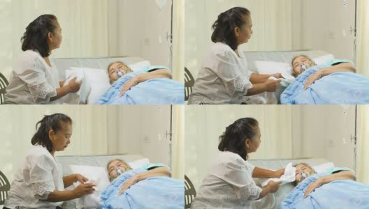 一位妇女正在医院病床上照顾她的母亲高清在线视频素材下载