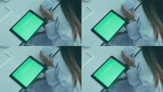 在实验室工作的科学家，正在展示她的带绿色屏幕的数字桌子高清在线视频素材下载