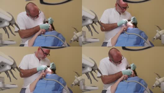 牙医在治疗一个女病人，手持枪伤高清在线视频素材下载