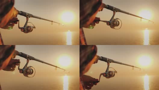 渔夫的手，握住旋转棒，旋转线圈手柄。爱好和活动高清在线视频素材下载