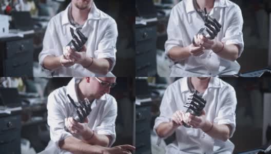 一位科学家工程师正在测试一个电子仿生假肢。他移动机械手臂的塑料手指。现代修复技术。科学家手中的控制论之手高清在线视频素材下载
