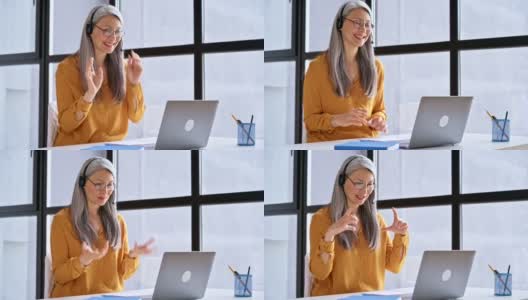 亚洲中年美女用笔记本电脑进行虚拟在线会议，白发苍苍的商务女士在网上进行视频会议交流，坐在现代的办公室里，进行在线交流的概念高清在线视频素材下载