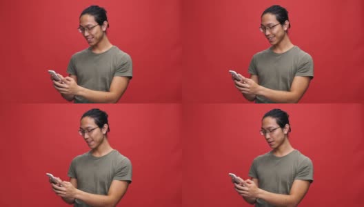 开朗的亚洲男人穿着t恤戴着眼镜在智能手机上写信息高清在线视频素材下载