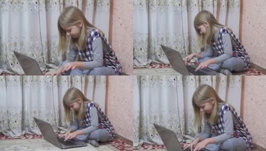 一个中学年龄的小女孩坐在家里的地板上使用笔记本电脑。用电脑做作业。高清在线视频素材下载