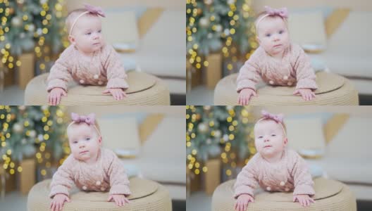 6个月大的可爱宝宝的特写照片。孩子的脸，头上戴着蝴蝶结，头上织着毛衣高清在线视频素材下载