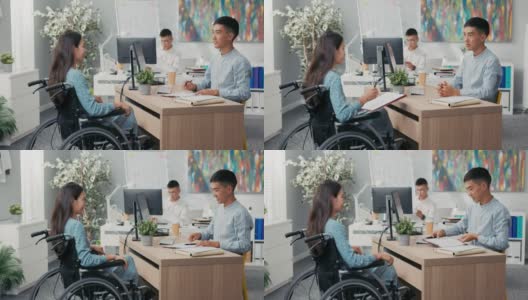 女人坐在轮椅上在办公室的桌子上，对面的雇主他们正在签署雇员合同男人伸出手，他们握手感谢对方的谈话祝贺高清在线视频素材下载