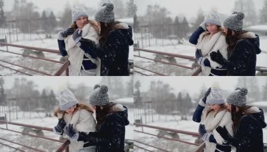 年轻美丽的女性站在和享受暴风雪在寒冷的冬日。高清在线视频素材下载