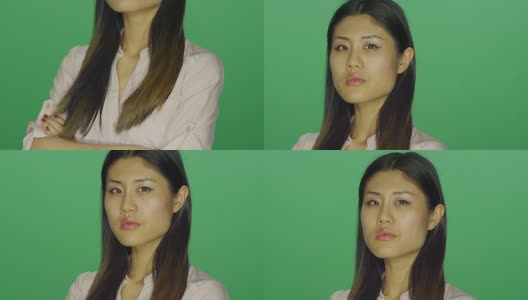 美丽的亚洲女人盯着她的双臂紧闭，在一个绿色屏幕的工作室背景高清在线视频素材下载