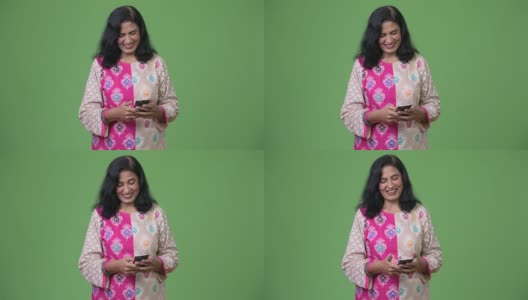 成熟快乐美丽的印度女人微笑着使用电话高清在线视频素材下载