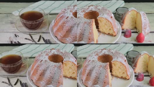 老式的沙蛋糕，一杯红茶和几片香草在木制的背景。蛋黄海绵蛋糕，草莓在乡村白色的背景高清在线视频素材下载