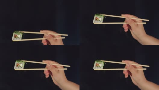 黑暗中女性用筷子手握寿司。高清在线视频素材下载