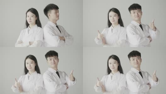 美丽的女医生和男医生背靠背站着，对着镜头微笑，亚洲医生，整形医生，慢动作拍摄高清在线视频素材下载