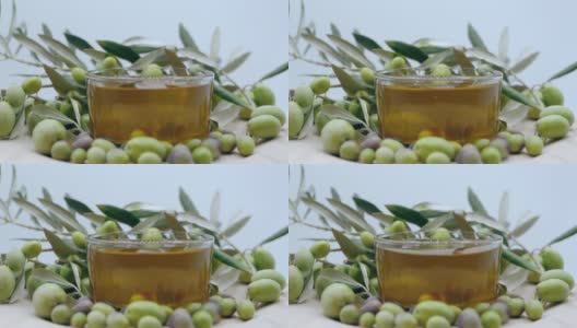 成熟的绿色橄榄倒入透明的碗中与天然橄榄油在慢动作，橄榄油工业和生产的健康有机产品从天然种植园，农业的概念高清在线视频素材下载