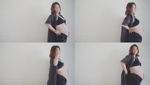 肖像吸引快乐的亚洲孕妇站着触摸她的大肚子与爱，怀孕，为人母，人们和期望的概念高清在线视频素材下载
