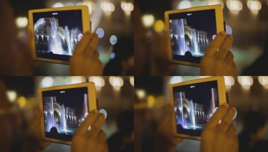 游客用便携式设备拍摄视频，音乐喷泉画面出现在屏幕上高清在线视频素材下载
