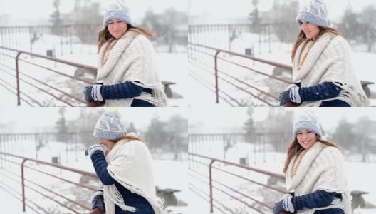 年轻美丽的女性站在和享受暴风雪在寒冷的冬日。高清在线视频素材下载