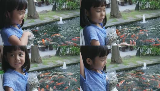 亚洲女孩在池塘里喂鲤鱼高清在线视频素材下载