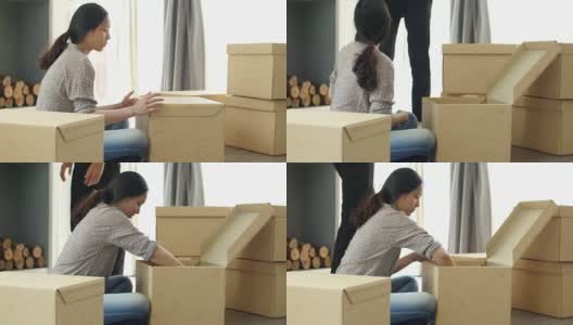 女人从硬纸板箱里为新家拆东西高清在线视频素材下载