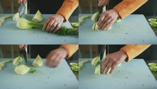 An Older Caucasian Woman Slices Fennel on a Cutting Board with a Kitchen Knife in a Commercial Kitchen高清在线视频素材下载