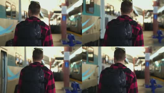 慢镜头:美丽的年轻男性背包客走在洛杉矶火车站的站台上高清在线视频素材下载