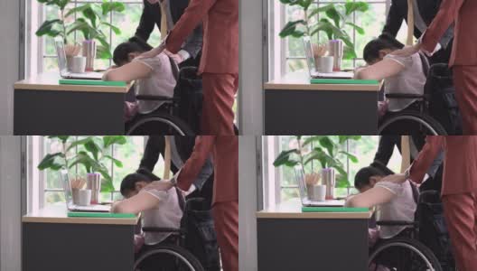 同事们在安慰坐在轮椅上的悲伤女人高清在线视频素材下载