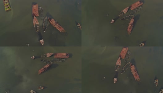 在美国纽约市史泰登岛的船墓地上沉没的生锈的废弃船只。向下看，正上方的航拍视频由无人机，与轨道摄像机运动。高清在线视频素材下载