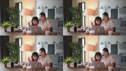 亚裔华人中年妇女在餐厅工作，用笔记本电脑打字，而她的女儿陪着她高清在线视频素材下载