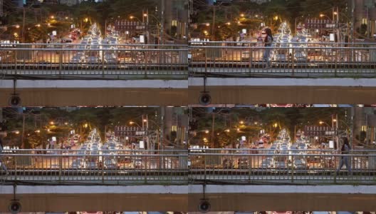 亚洲妇女拿着智能手机在人行天桥上快速行走。在一个大都市的夜晚，城市交通模糊。高清在线视频素材下载