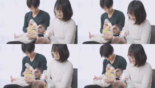亚洲父母正在给双胞胎婴儿喂奶高清在线视频素材下载