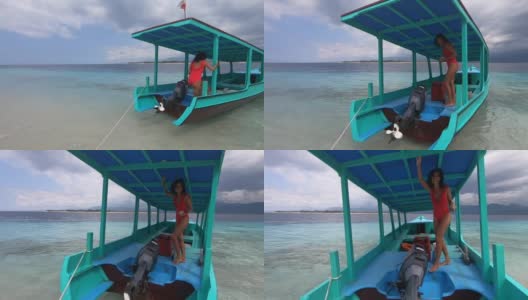乘坐蓝色帆船环游热带岛屿的激动人心的海洋之旅，穿着红色泳装的快乐女人高清在线视频素材下载