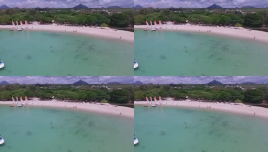 在印度洋和毛里求斯岛的阿尔比恩海滩。背景中的海岸线和人们在玩耍和日光浴高清在线视频素材下载