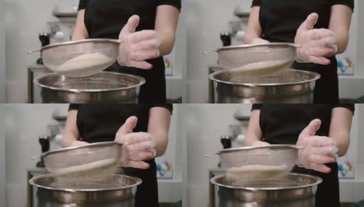 一名年轻女子在厨房用筛子筛面粉高清在线视频素材下载