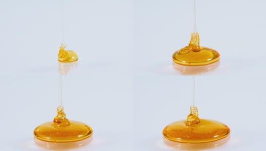 近浇金色甜蜜的蜂蜜滴在白色的背景，4K Dci分辨率高清在线视频素材下载