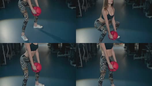 在健身房做下蹲和健身球的女人高清在线视频素材下载
