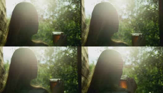 日落时分，女孩在户外喝热茶高清在线视频素材下载