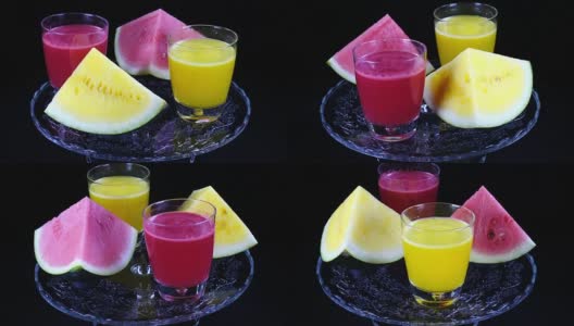 金字塔状的红黄西瓜和几杯鲜榨的西瓜汁，在黑色背景下对着时钟旋转近距离。高清在线视频素材下载