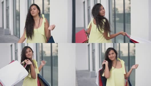 美丽的女孩模特在购物后与彩色的包在手里有一个好心情。缓慢的运动。肖像高清在线视频素材下载