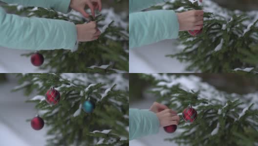 一位年轻女子在森林里装饰圣诞树高清在线视频素材下载