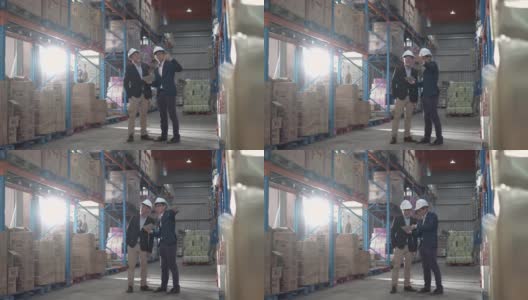 亚洲华人管理人员在仓库用数码平板电脑与白帽公司讨论高清在线视频素材下载