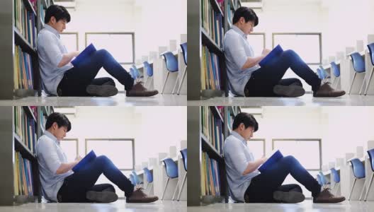 亚洲男大学生在图书馆地板上看书做研究高清在线视频素材下载