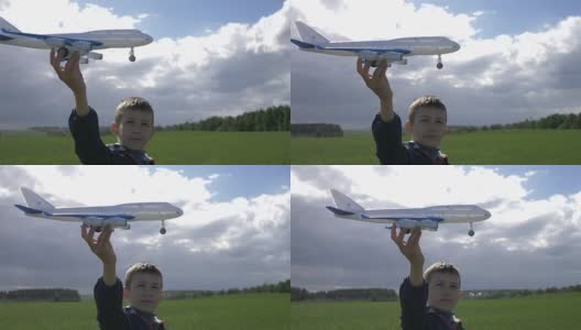 梦想家男孩手里拿着一架飞机，看着他高清在线视频素材下载