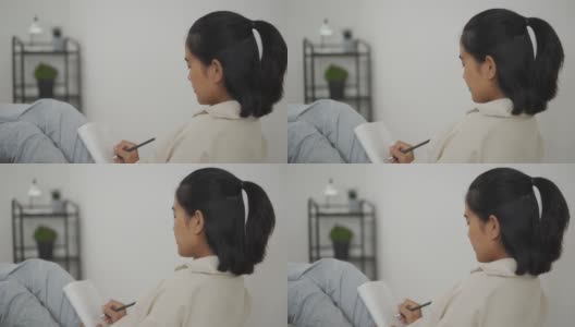 亚洲年轻女子在日记笔记本上写东西高清在线视频素材下载