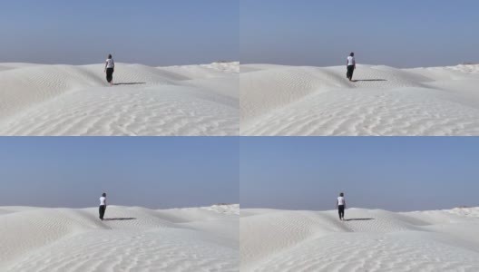 沙漠中行走的金发女人高清在线视频素材下载