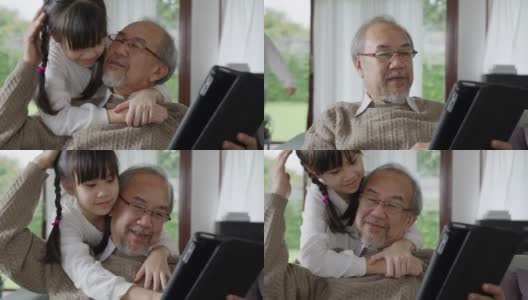 近距离观察年长的亚洲祖父母在家里用电脑平板电脑和孙辈一起玩和看。年轻女孩从背后拥抱年长的男人。高清在线视频素材下载