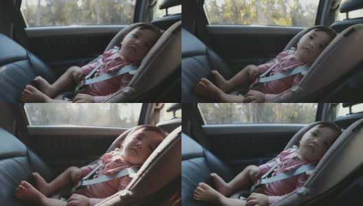 可爱的亚洲幼童女孩坐在汽车座椅上，感觉困倦，而与家人旅行。高清在线视频素材下载