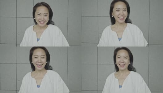 一个迷人的亚洲资深女性微笑的慢动作视频高清在线视频素材下载