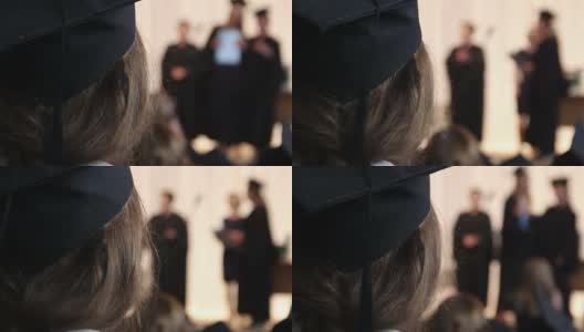 女孩戴着学术帽看着学生接受文凭，大学高清在线视频素材下载