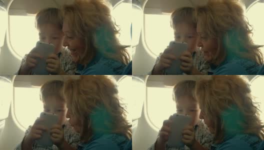 孩子和奶奶在飞机上玩手机高清在线视频素材下载